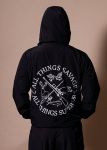 Person wearing a black hoodie with text and graphics on the back against a brown background